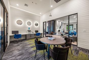 A conference room with a round table and chairs.